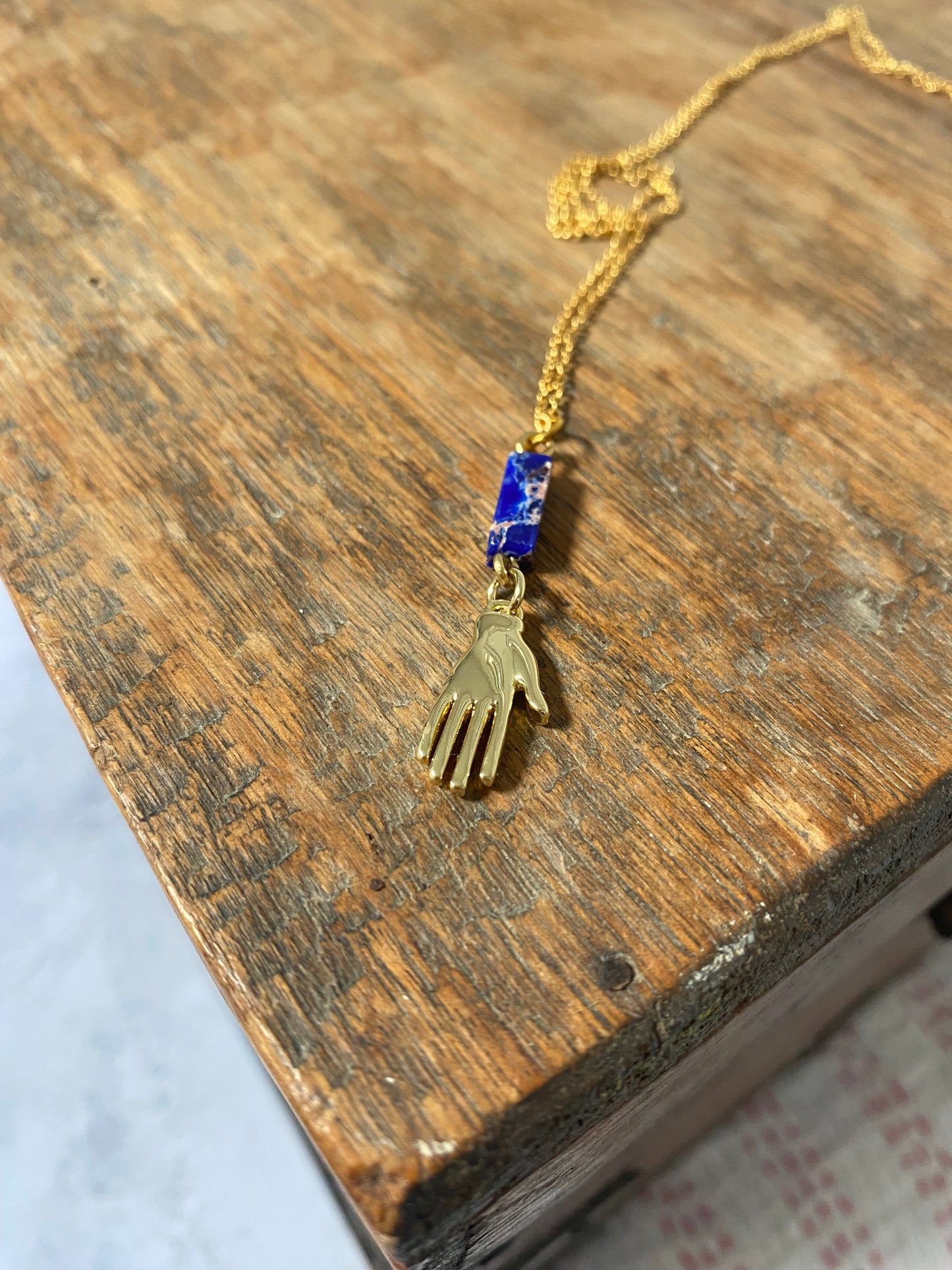 Golden Hand Charm with Lapis Lazuli Bead